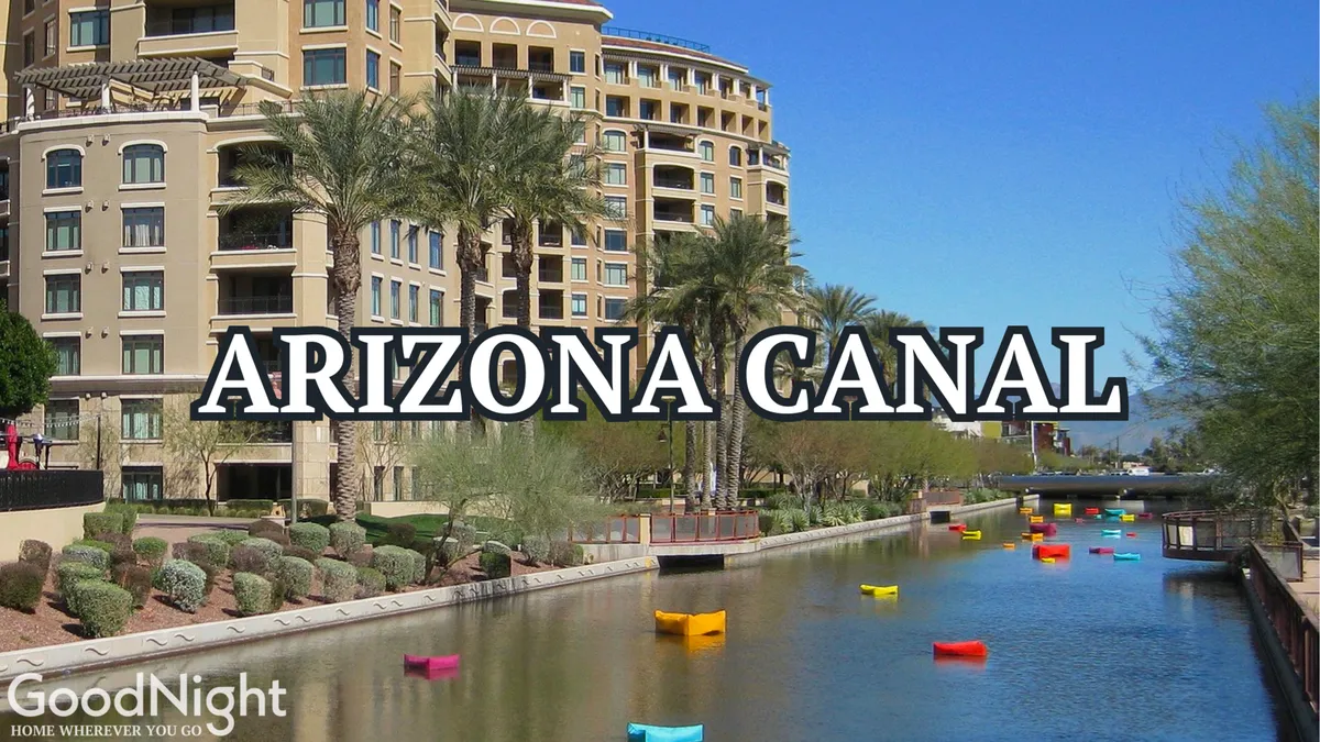 A lively exterior shot of the Arizona Canal lined with palm trees, colorful boats, and luxury buildings. The scene invites walking along the water, boat rides, or enjoying outdoor dining, all under a cheerful, sunny sky.